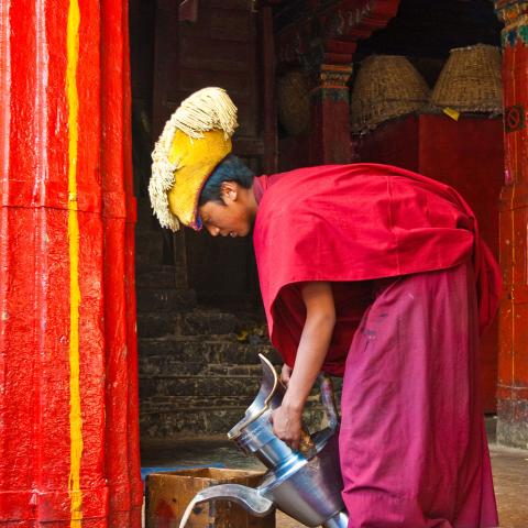 A monk pours butter tea in Tashilhunpo Monastery, Tibet.