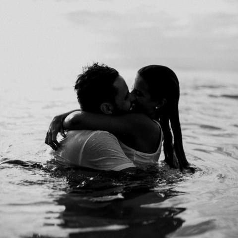 Man and Woman Kissing Together on Body of Water Man and Woman Kissing Together on Body of Water